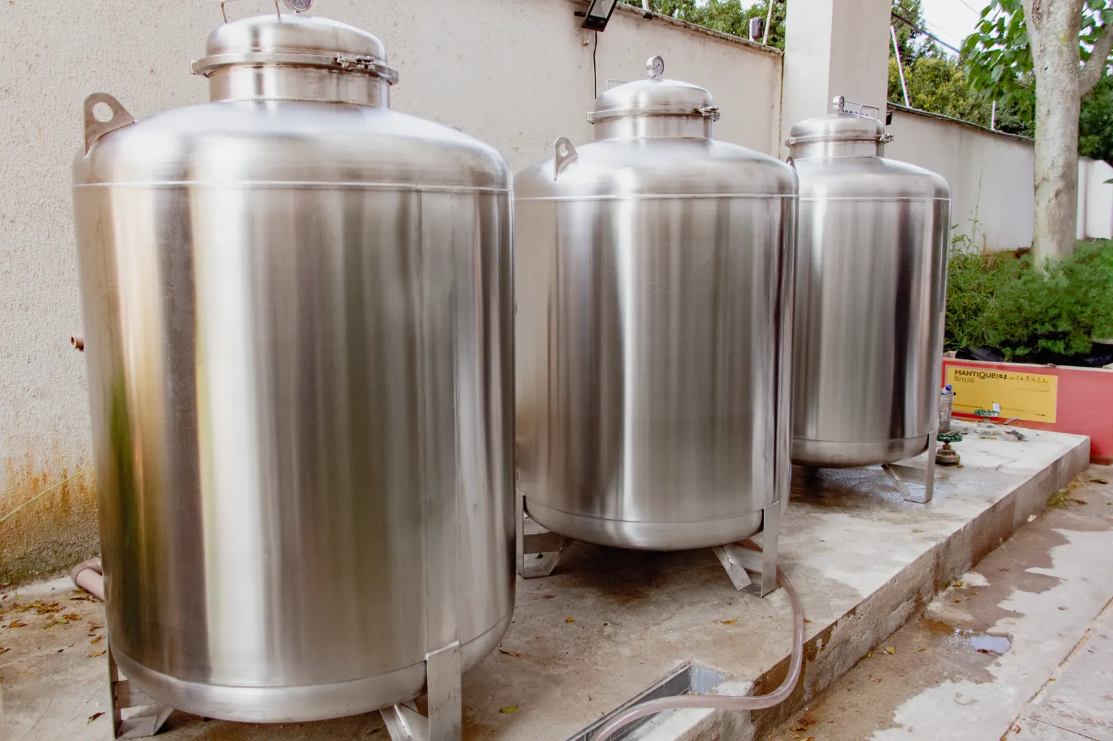Três filtros centrais de água em aço inox instalados lado a lado em área externa