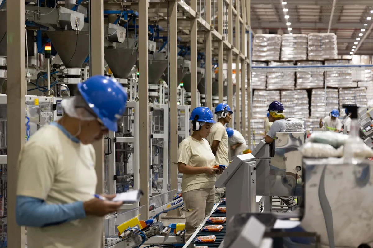 Colaboradores na linha de produção Camil