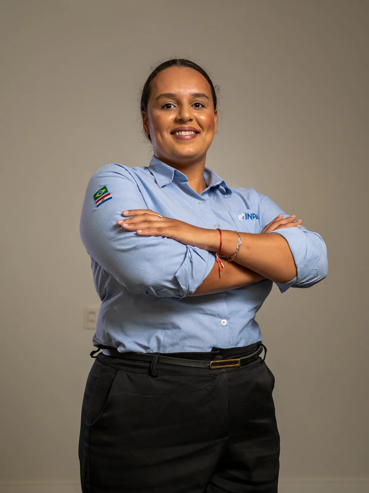 Funcionária da Inpasa de braços cruzados, com o uniforme da empresa