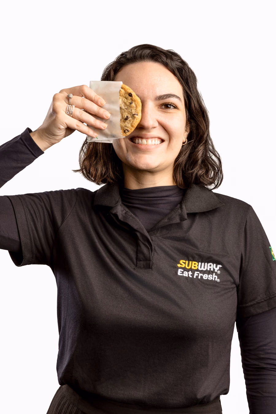 Colaboradora do Subway com um cookie na frente do olho; em seguida, a foto troca e aparece uma colaboradora com a coroa do Burger King